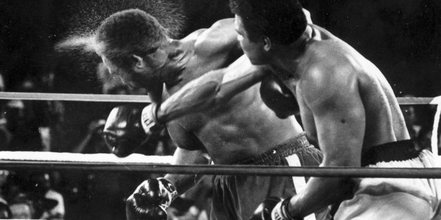 FILE - This is a Oct. 30, 1974,  file photo showing George Foreman taking a right to the head from ...