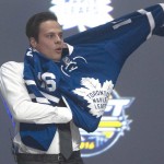 Toronto Maple Leafs pick Auston Matthews pulls on his sweater at the NHL hockey draft, Friday, June 24, 2016, in Buffalo, N.Y. (Nathan Denette/The Canadian Press via AP)