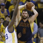 Cleveland Cavaliers forward Kevin Love (0) is guarded by Golden State Warriors forward Draymond Green during the first half of Game 1 of basketball's NBA Finals in Oakland, Calif., Thursday, June 2, 2016. (AP Photo/Marcio Jose Sanchez)