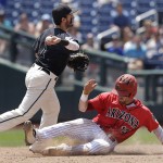 Coastal Carolina shortstop Michael Paez (1) throws to first base to complete a double play as Arizona's Cody Ramer (13) slides on a Zach Gibbons ground ball in the fifth inning in Game 3 of the NCAA College World Series baseball finals in Omaha, Neb., Thursday, June 30, 2016. (AP Photo/Nati Harnik)