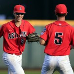 Arizona left fielder Kyle Lewis, left, smiles as he is congratulated by Louis Boyd after catching a fly ball by UC Santa Barbara's Dempsey Grover to end the top of the fourth inning of an NCAA College World Series baseball game, Wednesday, June 22, 2016, in Omaha, Neb. (AP Photo/Nati Harnik)