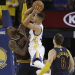 Golden State Warriors guard Stephen Curry, center, shoots between Cleveland Cavaliers forward LeBron James and guard Matthew Dellavedova (8) during the second half of Game 1 of basketball's NBA Finals in Oakland, Calif., Thursday, June 2, 2016. (AP Photo/Marcio Jose Sanchez)
