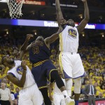 Golden State Warriors forward Draymond Green (23) grabs a rebound over center Festus Ezeli (31) and Cleveland Cavaliers center Tristan Thompson (13) during the second half of Game 1 of basketball's NBA Finals in Oakland, Calif., Thursday, June 2, 2016. (AP Photo/Marcio Jose Sanchez)