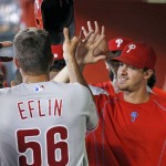 Philadelphia Phillies' Zach Eflin (56) celebrates his run scored against the Arizona Diamondbacks with Aaron Nola, right, and other teammates in the dugout during the fifth inning of a baseball game Wednesday, June 29, 2016, in Phoenix. (AP Photo/Ross D. Franklin)