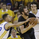 Cleveland Cavaliers forward Kevin Love, center, is defended by Golden State Warriors guard Stephen Curry (30) and forward Anderson Varejao during the first half of Game 7 of basketball's NBA Finals in Oakland, Calif., Sunday, June 19, 2016. (AP Photo/Marcio Jose Sanchez)