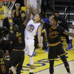 Golden State Warriors guard Stephen Curry (30) shoots between Cleveland Cavaliers guard Kyrie Irving (2) and guard Iman Shumpert (4) during the first half of Game 7 of basketball's NBA Finals in Oakland, Calif., Sunday, June 19, 2016. (AP Photo/Eric Risberg)