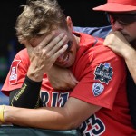 Arizona's Zach Gibbons (23) is comforted by Ray McIntire after losing to Coastal Carolina 4-3 in Game 3 of the NCAA College World Series baseball finals in Omaha, Neb., Thursday, June 30, 2016. (AP Photo/Ted Kirk)