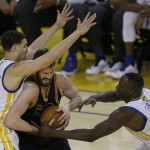 Cleveland Cavaliers forward Kevin Love, center, is defended by Golden State Warriors guard Klay Thompson, left, and forward Draymond Green (23) during the second half of Game 1 of basketball's NBA Finals in Oakland, Calif., Thursday, June 2, 2016. (AP Photo/Ben Margot)