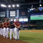 Arizona Diamondbacks manager Chip Hale, right, hitting coach Dave Magadan, second from right, pitching coach Mike Butcher, third from right, and bench coach Glenn Sherlock, fourth from right, join other Diamondbacks coaches and players for a moment of silence for the Orlando, Fla., mass shooting victims prior to a baseball game against the Miami Marlins, Sunday, June 12, 2016, in Phoenix. (AP Photo/Ross D. Franklin)