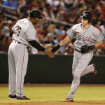 Miami Marlins' J.T. Realmuto, right, celebrates with third base coach Lenny Harris after hitting a solo home run during the fourth inning against the Arizona Diamondbacks in a baseball game, Saturday, June 11, 2016, in Phoenix. (AP Photo/Rick Scuteri)