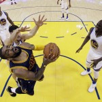 Cleveland Cavaliers' Kyrie Irving, bottom left, tries to get a shot past Golden State Warriors' Klay Thompson, left, and Draymond Green (23) during the first half in Game 1 of basketball's NBA Finals Thursday, June 2, 2016, in Oakland, Calif. (AP Photo/Marcio Jose Sanchez, Pool)