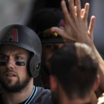 Arizona Diamondbacks' Chris Owings celebrates with teammates in the dugout after scoring on a Yasmany Tomas 2 RBI double during the second inning of a baseball game against the Chicago Cubs, Sunday, June 5, 2016, in Chicago. (AP Photo/Paul Beaty)