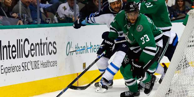 Dallas Stars' Alex Goligoski (33) tries to clear the puck from behind the net as Winnipeg Jets' Dus...