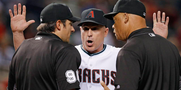 Arizona Diamondbacks manager Chip Hale, middle, argues with umpires Mark Ripperger, left, and Kerwi...