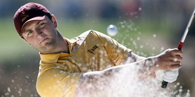 Jon Rahm hits out of a sand trap on the fourth hole during the final round of the Phoenix Open golf...