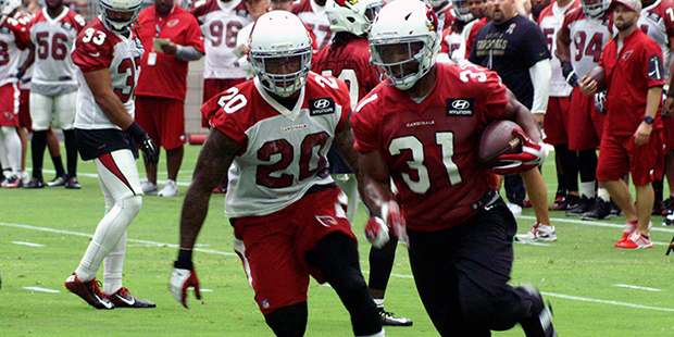 David Johnson turns the corner with the ball as Deone Bucannon pursues during training camp. (Photo...