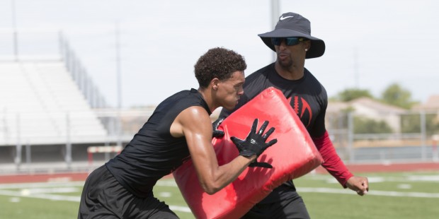 Phoenix College wide receiver coach Kerry Taylor works at Camp 29, a summer football camp for local...