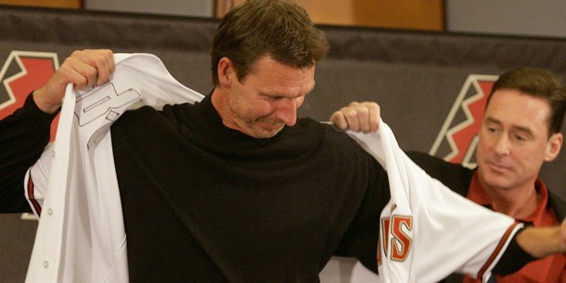 Arizona Diamondbacks pitcher Randy Johnson, left, is assisted by manager Bob Melvin in donning a je...