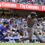 Arizona Diamondbacks' Jean Segura, right, hits an RBI double to score Chris Owings during the second inning of a baseball game as Los Angeles Dodgers catcher Yasmani Grandal watches, in Los Angeles, Saturday, July 30, 2016. (AP Photo/Kelvin Kuo)
