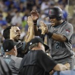 Arizona Diamondbacks' Yasmany Tomas, right, is greeted by teammates after scoring on a single by Michael Bourn during the seventh inning of a baseball game against the Los Angeles Dodgers, Friday, July 29, 2016, in Los Angeles. (AP Photo/Jae C. Hong)