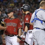 Los Angeles Dodgers' A.J. Ellis, second from right, checks his face as teammate Justin Turner, right, looks on as Arizona Diamondbacks manager Chip Hale (3) argues a batter interference call against Nick Ahmed, middle, with umpire Bob Davidson (61) during the second inning of a baseball game Sunday, July 17, 2016, in Phoenix. (AP Photo/Ross D. Franklin)