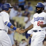 Los Angeles Dodgers' Adrian Gonzalez, left, and Andrew Toles celebrate after they scored on a double by Joc Pederson during the second inning of a baseball game against the Arizona Diamondbacks, Friday, July 29, 2016, in Los Angeles. (AP Photo/Jae C. Hong)