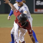 Arizona Diamondbacks' Michael Bourn, front, arrives safely at third base ahead of the tag by Los Angeles Dodgers' Justin Turner, back, during the first inning of a baseball game Sunday, July 17, 2016, in Phoenix. (AP Photo/Ross D. Franklin)