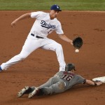 Los Angeles Dodgers shortstop Corey Seager, top, fields a throw on a pick-off attempt on Arizona Diamondbacks' Chris Owings, who was safe during the second inning of a baseball game in Los Angeles, Saturday, July 30, 2016. (AP Photo/Kelvin Kuo)