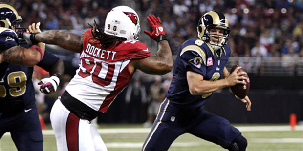 St. Louis Rams quarterback Sam Bradford, right, scrambles as Arizona Cardinals defensive end Darnel...