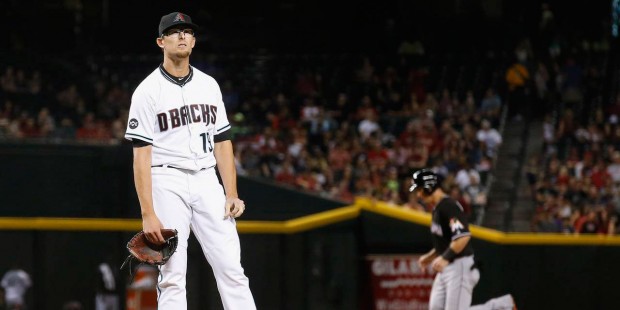 Arizona Diamondbacks' Tyler Clippard, left, pauses on the mound after giving up a grand slam to Mia...
