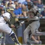 Milwaukee Brewers' Martin Maldonado waits for the throw as Arizona Diamondbacks' Rickey Weeks is able to get past and score during the fourth inning of a baseball game Monday, July 25, 2016, in Milwaukee. (AP Photo/Tom Lynn)