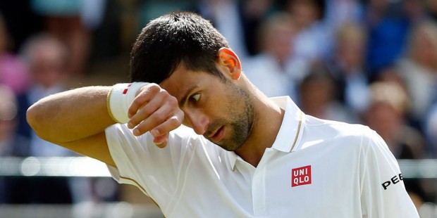 Novak Djokovic of Serbia wipes his face during his men's singles match against Sam Querrey of the U...