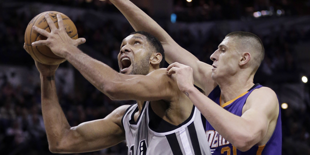San Antonio Spurs' Tim Duncan, left, shoots around Phoenix Suns' Alex Len, right, during the first ...