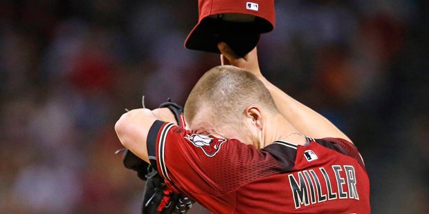 Arizona Diamondbacks' Shelby Miller wipes sweat from his forehead as he struggles, giving up five r...