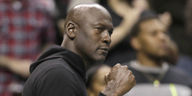 Charlotte Hornets owner Michael Jordan pumps his fist as he watches his team against the Washington...