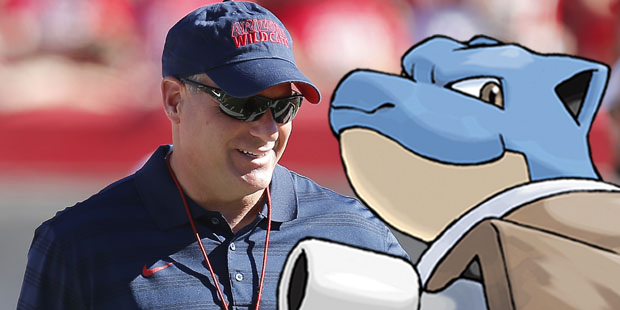 Rich Rodriguez confers with quarterback Blastoise, who has a water cannon for an arm.