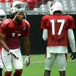 Receiver Larry Fitzgerald instructs teammate Franky Okafor during training camp on Aug. 1. (Photo by Adam Green/Arizona Sports)