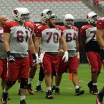 Offensive linemen walk onto the main field during training camp Aug. 21. (Photo by Adam Green/Arizona Sports)