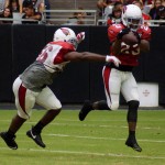 RB Chris Johnson catches a pass while LB Donald Butler covers during training camp Aug. 8. (Photo by Adam Green/Arizona Sports)