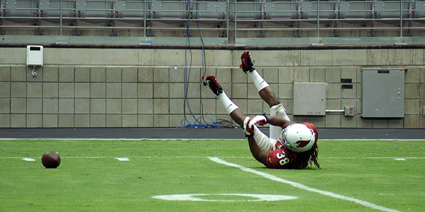 Running back Andre Ellington lies on the ground as a pass falls incomplete during training camp Aug...