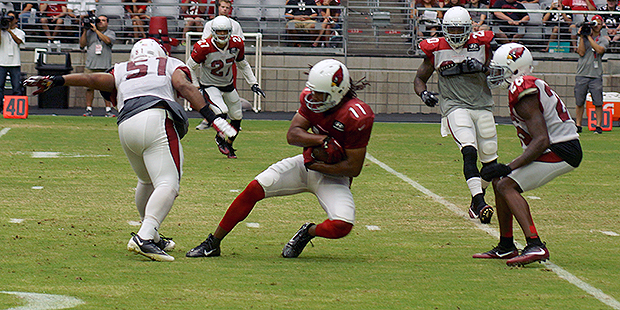 Larry Fitzgerald holds onto the ball after being hit by Kevin Minter during training camp Aug. 9. (...