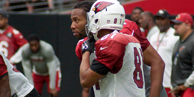 Larry Fitzgerald leans in and offers advice during a training camp practice Aug. 21. (Photo by Adam...