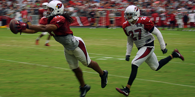 Receiver Larry Fitzgerald reaches out for the ball while Tyvon Branch is in coverage during the tea...