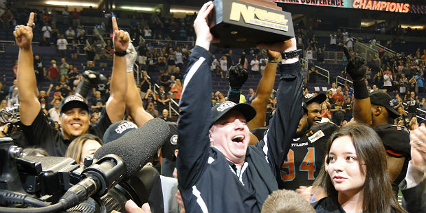 Rattlers head coach Kevin Guy holds up the National Conference Championship trophy after his team d...