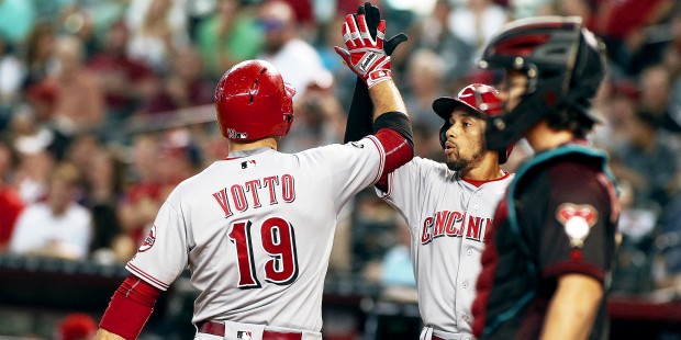 Cincinnati Reds' Joey Votto (19) is congratulated by teammate Billy Hamilton, center, after hitting...