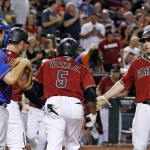Arizona Diamondbacks' Rickie Weeks Jr. celebrates his three-run home run with Paul Goldschmidt (44) and Zack Godley, second from left, as New York Mets' Travis d'Arnaud, left, watches during the fifth inning of a baseball game Wednesday, Aug. 17, 2016, in Phoenix. (AP Photo/Ross D. Franklin)