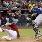 
              Milwaukee Brewers' Martin Maldonado, right, looks down after tagging out Arizona Diamondbacks' Chris Owings, left, who was trying to score a run during the fifth inning of a baseball game Sunday, Aug. 7, 2016, in Phoenix. (AP Photo/Ross D. Franklin)
            