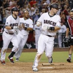 Arizona Diamondbacks' Paul Goldschmidt, right, scores the game-winning run as teammates Brandon Drury, left, Chris Owings, second from left, and Yasmany Tomas all run to join the celebration in the 11th inning of a baseball game against the Milwaukee Brewers Friday, Aug. 5, 2016, in Phoenix. The Diamondbacks defeated the Brewers 3-2. (AP Photo/Ross D. Franklin)