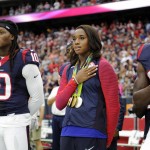 Olympic gold medalist Simone Manuel, center, stands with the Houston Texans for the national anthem prior to an NFL preseason football game against the Arizona Cardinals, Sunday, Aug. 28, 2016, in Houston. (AP Photo/Jeff Roberson)