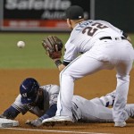 Milwaukee Brewers' Jonathan Villar, left, slides safely into third base after a double and a fielding error by Arizona Diamondbacks' Yasmany Tomas, as Diamondbacks' Jake Lamb (22) waits for the late throw during the first inning of a baseball game Friday, Aug. 5, 2016, in Phoenix. (AP Photo/Ross D. Franklin)